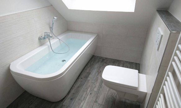 Badewanne unter der Dachschräge mit Boden in Holzoptik